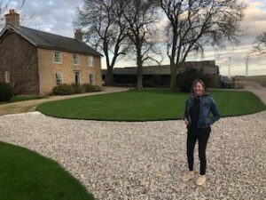 Photograph of Anna Whittome in front of farm building