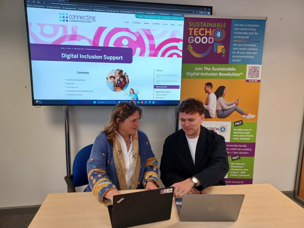 Sue Gowling from ST4G and Will Plant of Connecting Cambridgeshire sitting with two laptops looking happy and smiling.
