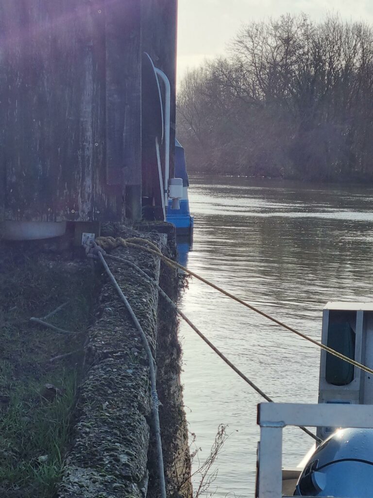 Image shows a flood sensor attached to the wall next to the river in St Ives above the water level.
