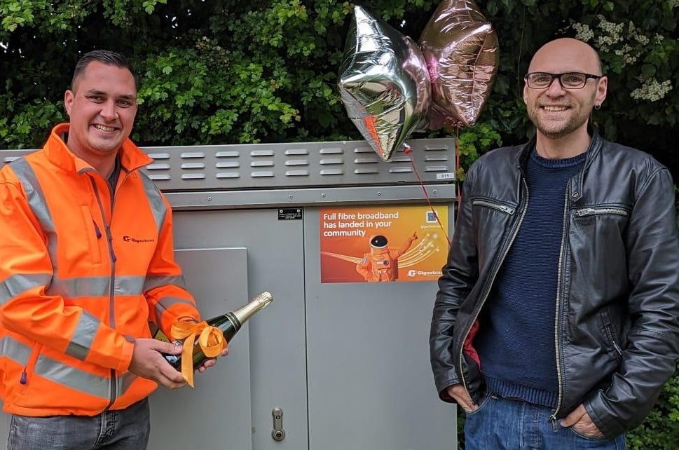 Gigaclear Project Delivering Lead Chris Baldwin presenting Mr Soper with a bottle of champagne.